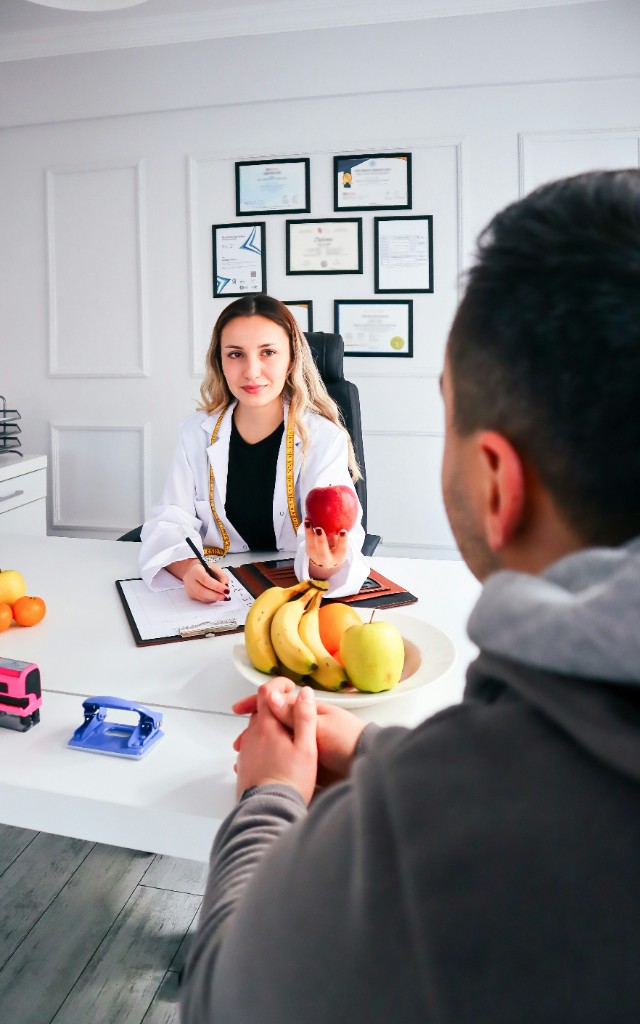 A personal nutrition consultation with fruit and a written plan on the desk